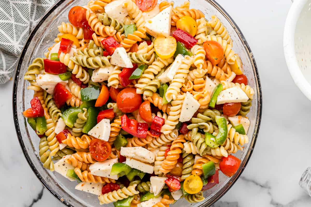 tossed tricolor pasta salad in a glass bowl.