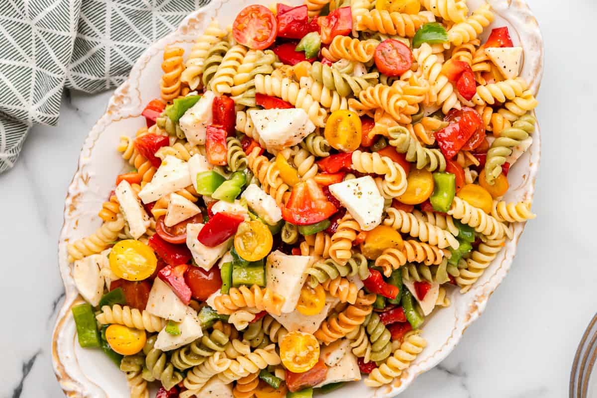tricolor pasta salad in a white serving bowl.