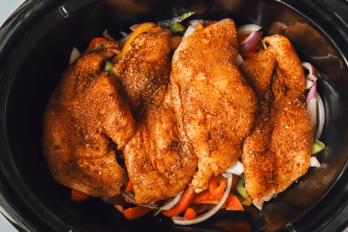Spice rubbed chicken breasts on top of the veggies in the crockpot. 