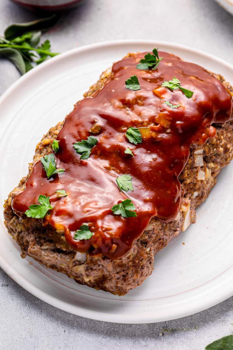 close up of glazed instant pot meatloaf on a white serving plate.