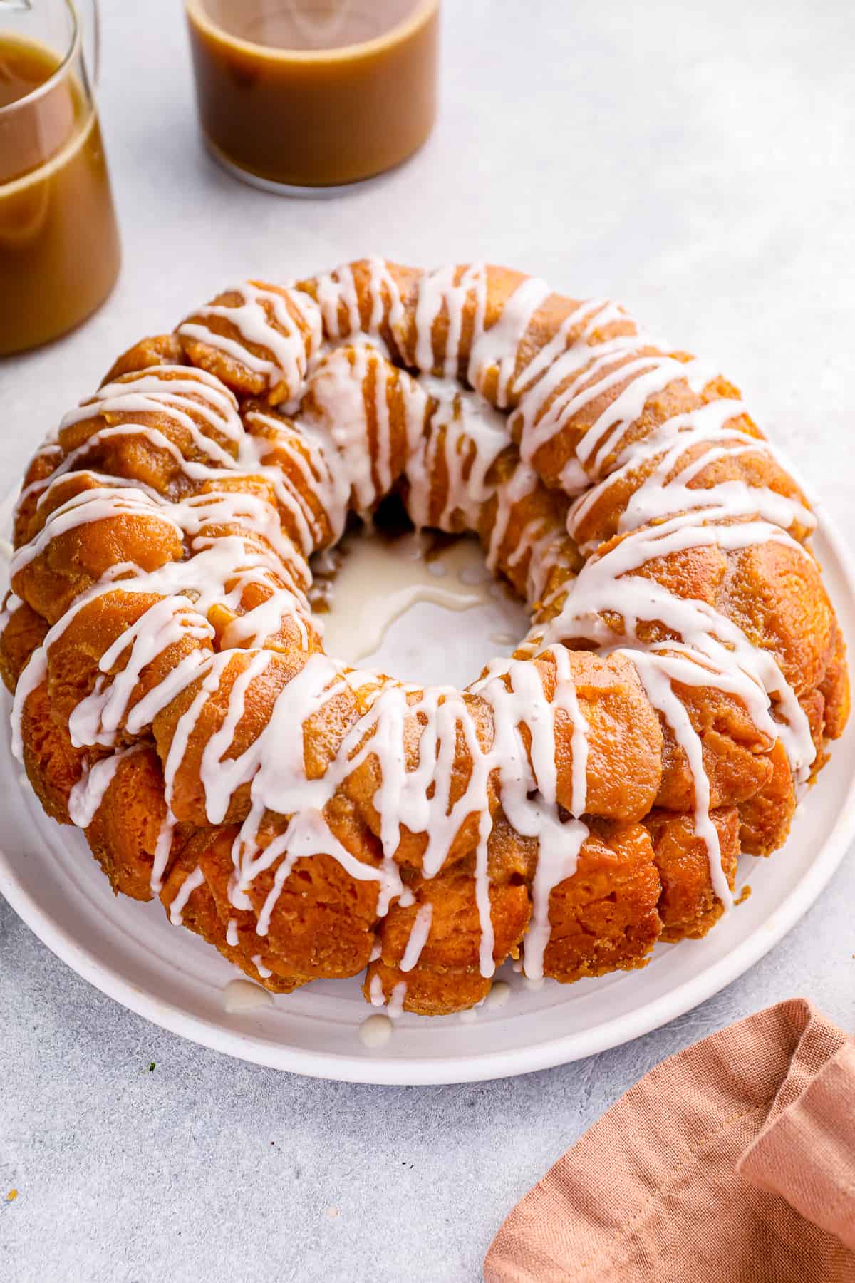 Iced easy monkey bread on a white serving plate.
