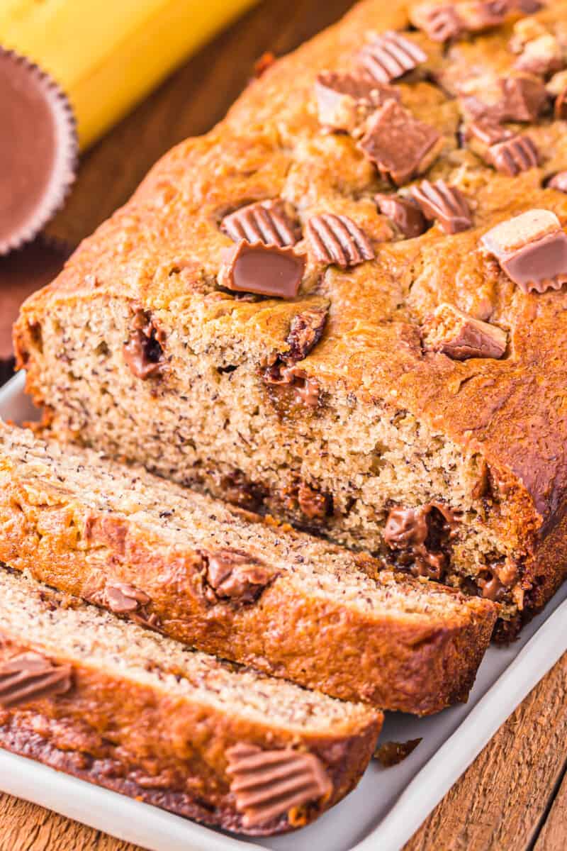 close up of sliced reeses peanut butter cup banana bread on a white plate.