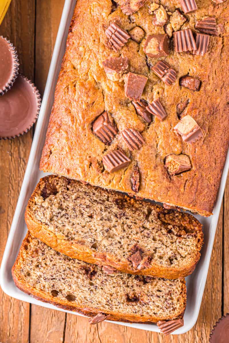 overhead view of sliced reeses peanut butter cup banana bread on a white plate.