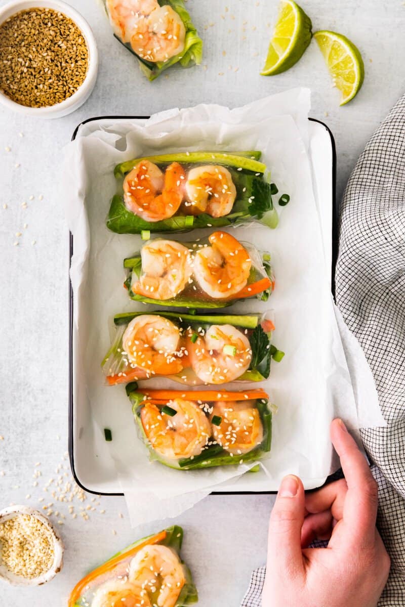 4 shrimp summer rolls in a white rectangular tray.