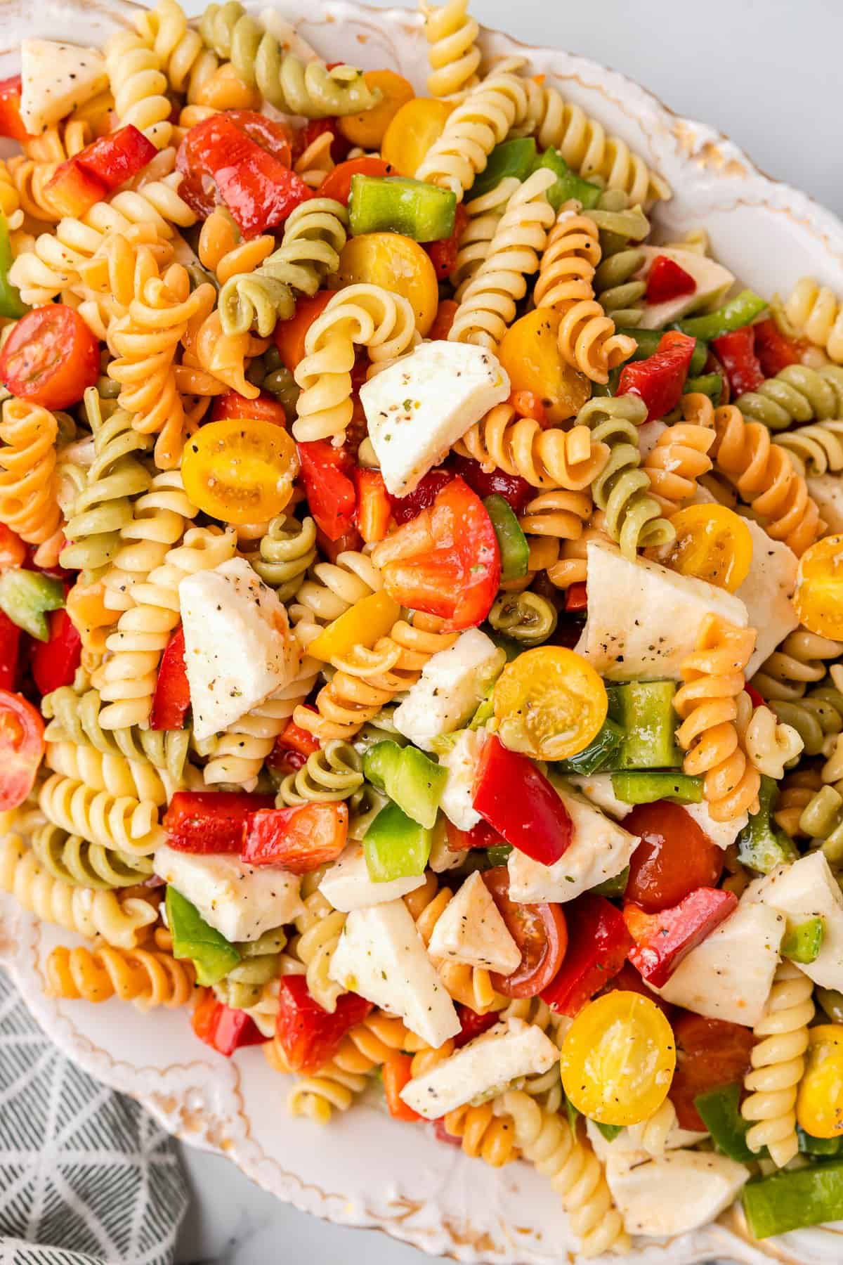 tricolor pasta salad in a white serving bowl.