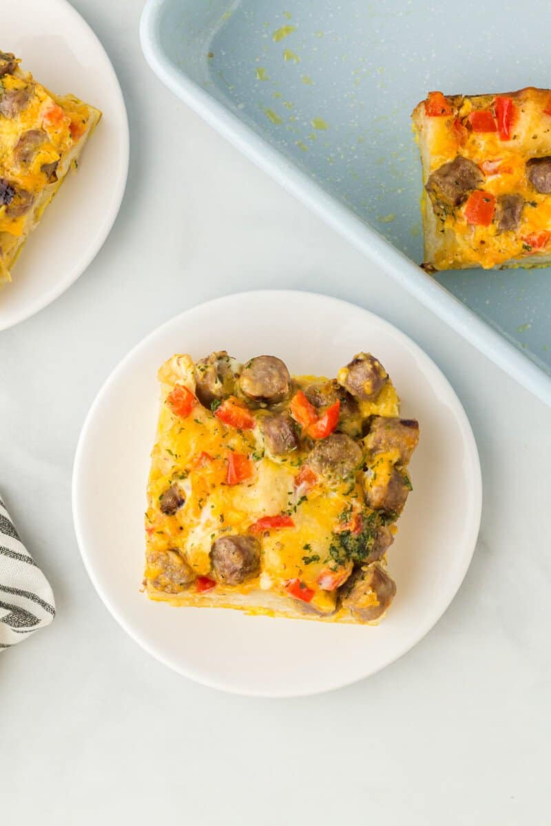 a slice of biscuit breakfast casserole on a white plate.