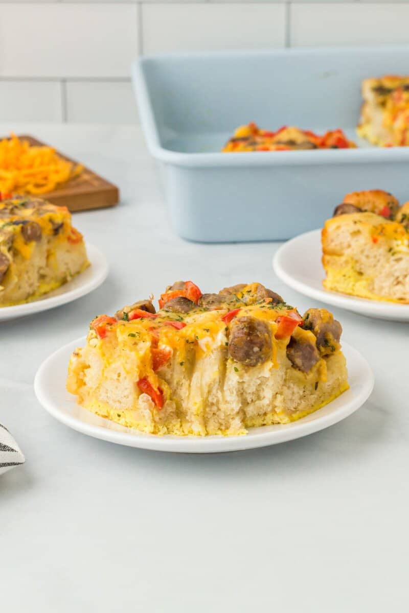 a bitten slice of biscuit breakfast casserole on a white plate.