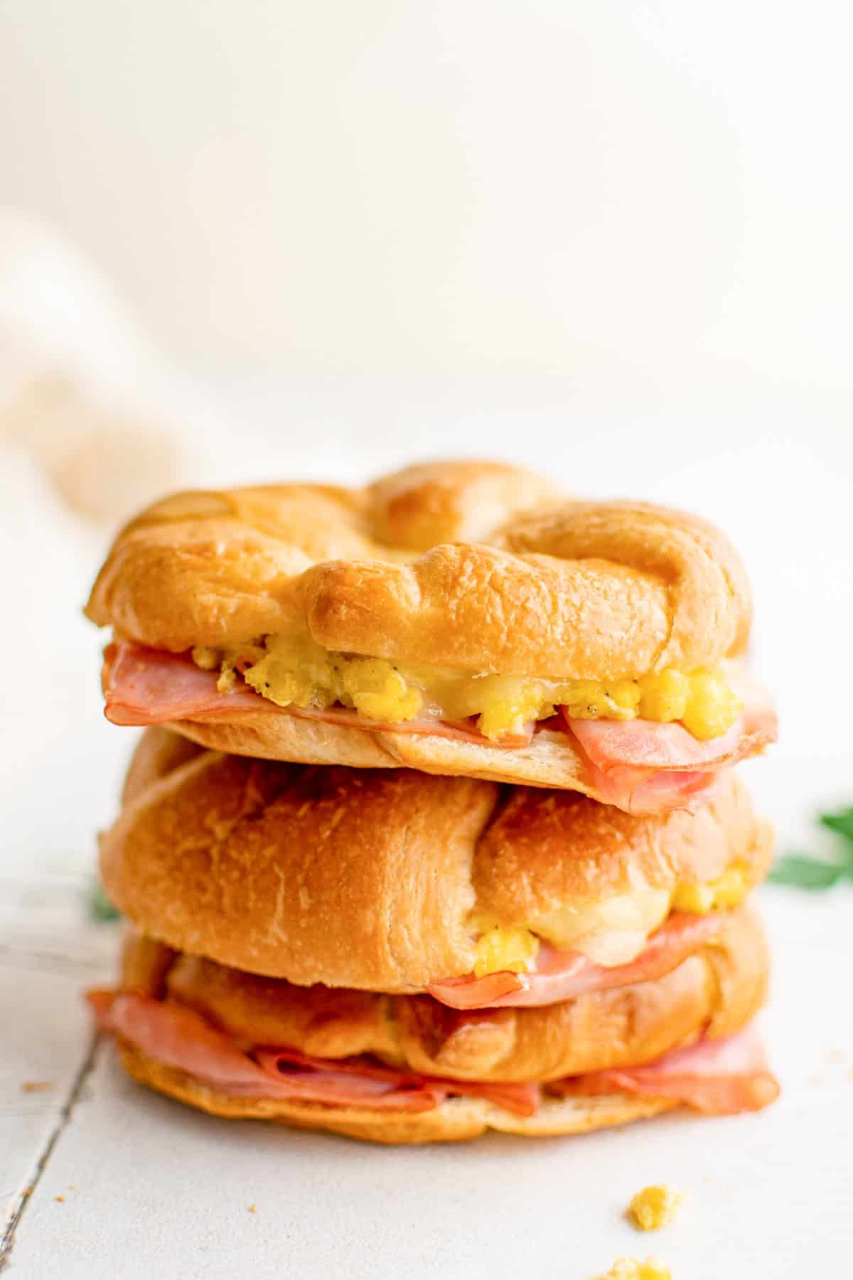 2 stacked croissant breakfast sandwiches on a table.