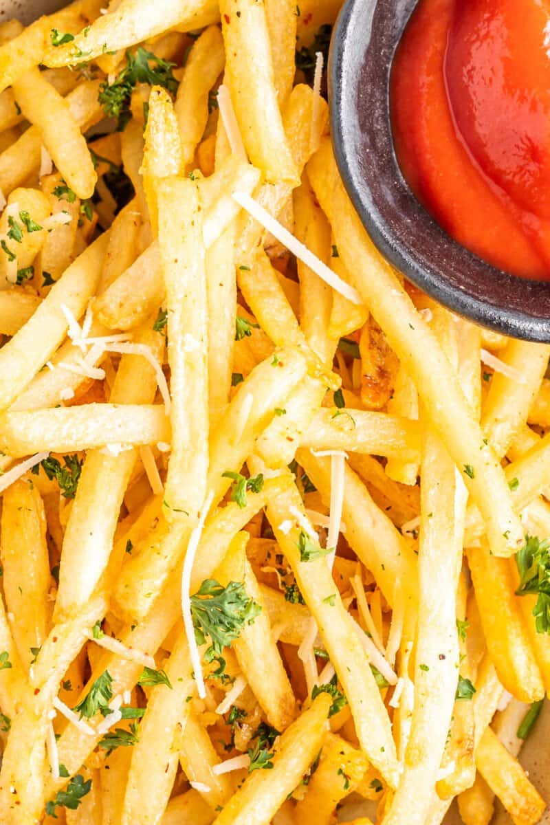 close up of garlic parmesan fries with ketchup.