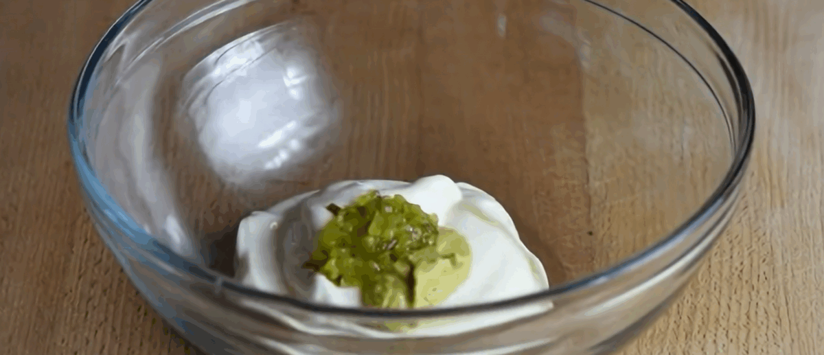 Making the dressing for the ham salad in a glass bowl.