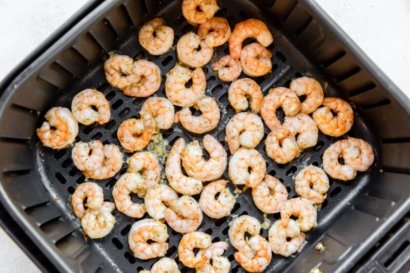 cooked shrimp in an air fryer basket.