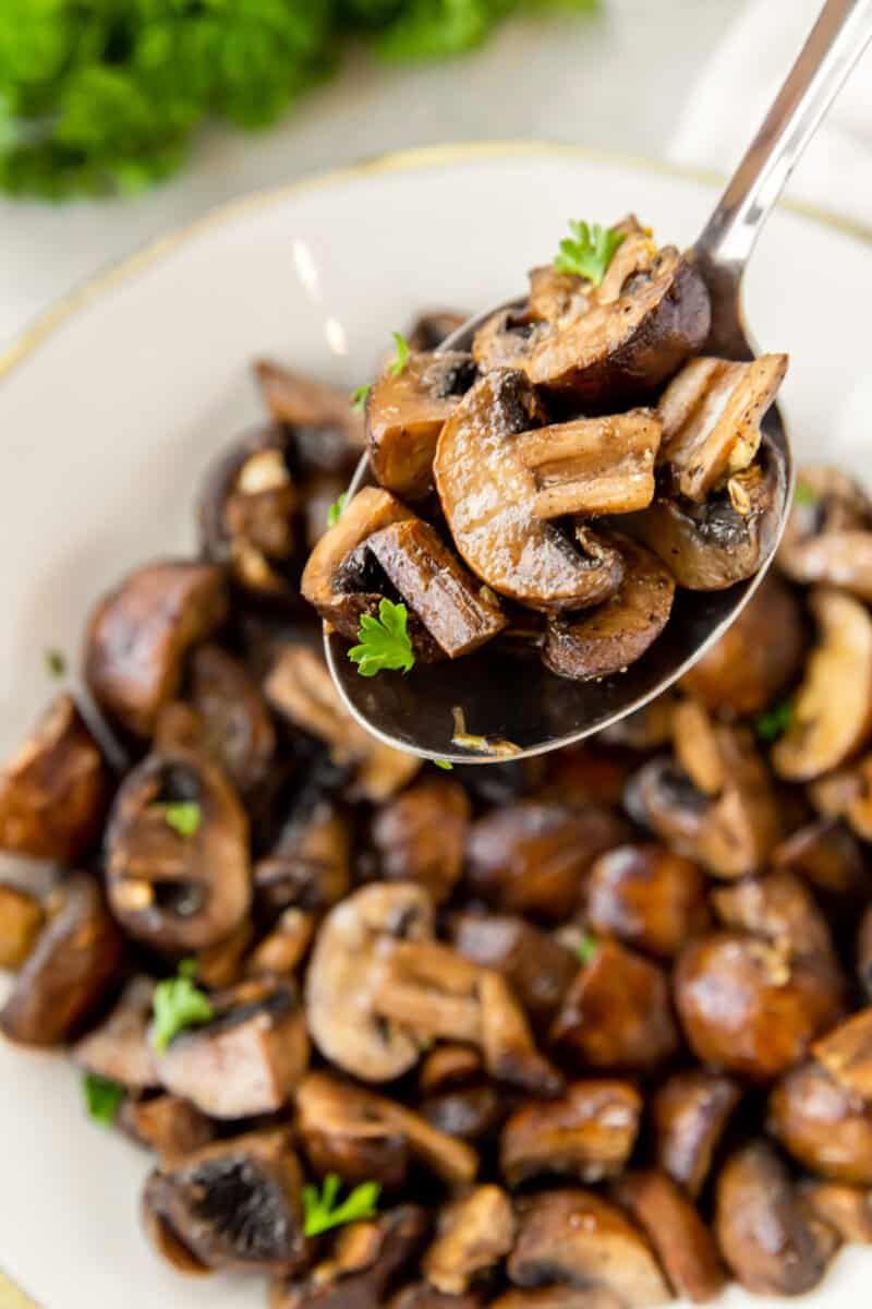 a spoonful of air fryer mushrooms in a white bowl.