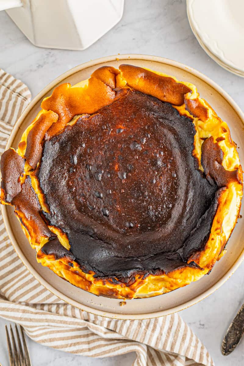 overhead view of basque cheesecake on a white cake stand.