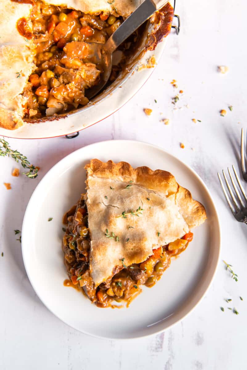 a slice of beef pot pie on a white plate.