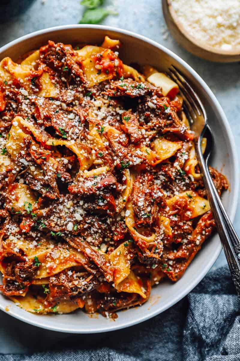 beef ragu in a white bowl with a fork.