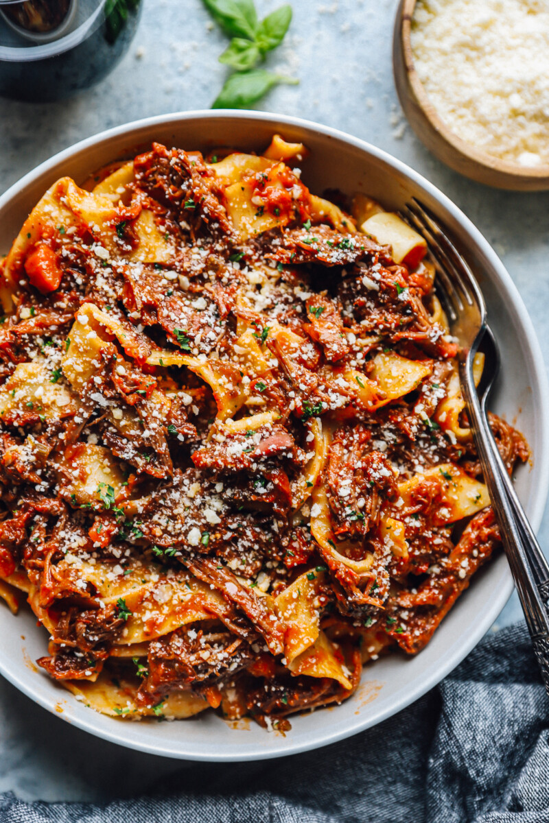 beef ragu in a white bowl with a fork.