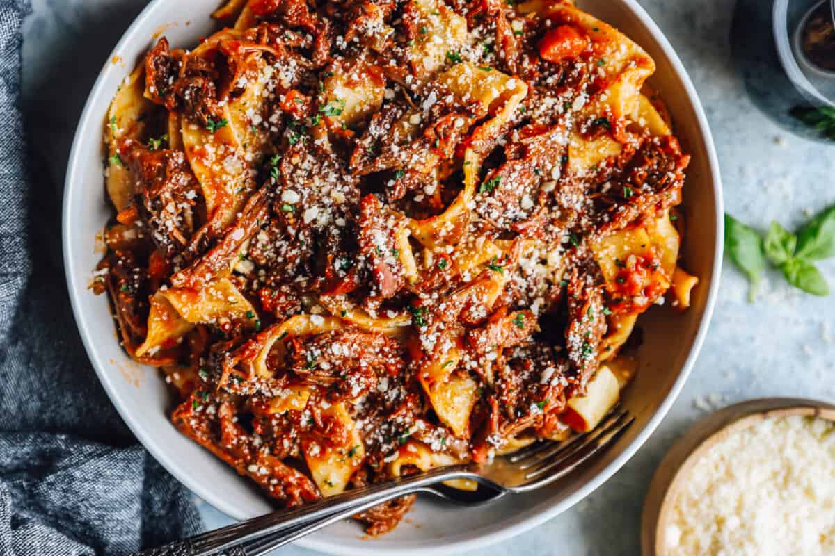 beef ragu in a white bowl with a fork.