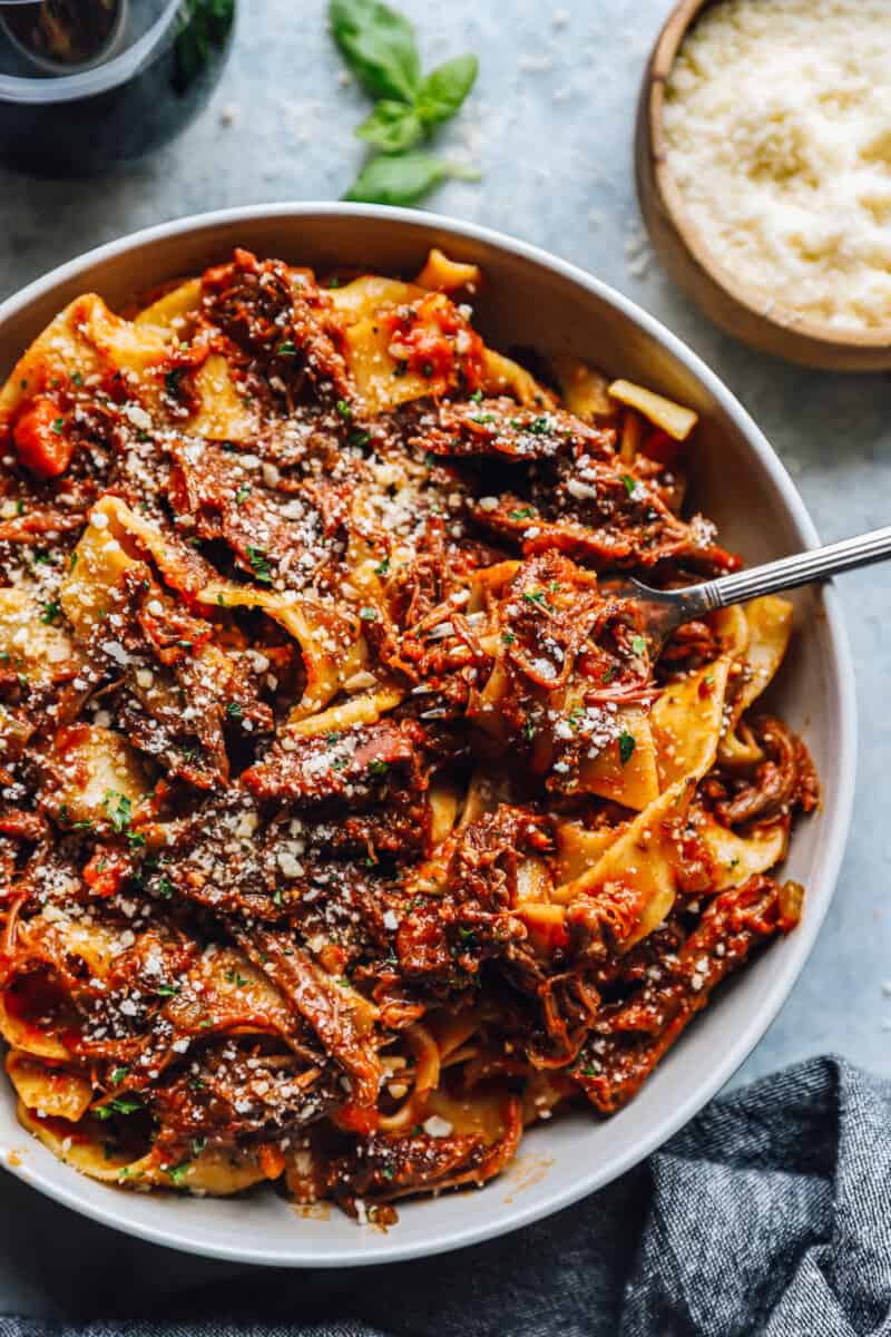 beef ragu in a white bowl with a fork.