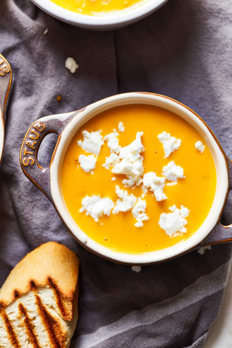 This Beer Cheese Soup recipe is so delicious and made in just 15 minutes! This creamy comfort food is the perfect winter dinner recipe. If you love cheese and beer (what could be better?), this easy beer cheese soup is just for you. bowl of beer cheese soup with a slice of bread