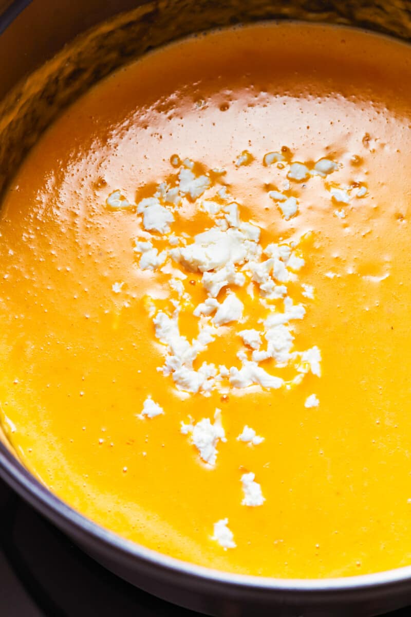 This Beer Cheese Soup recipe is so delicious and made in just 15 minutes! This creamy comfort food is the perfect winter dinner recipe. If you love cheese and beer (what could be better?), this easy beer cheese soup is just for you. close up on a pot filled with beer cheese soup
