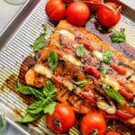 stuffed salmon and tomatoes on a baking tray