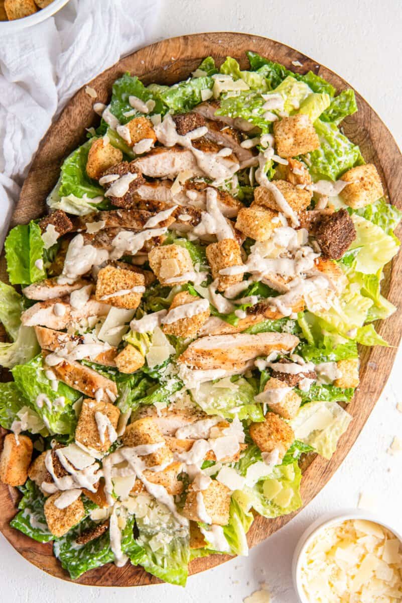 chicken caesar salad in a wooden serving bowl.