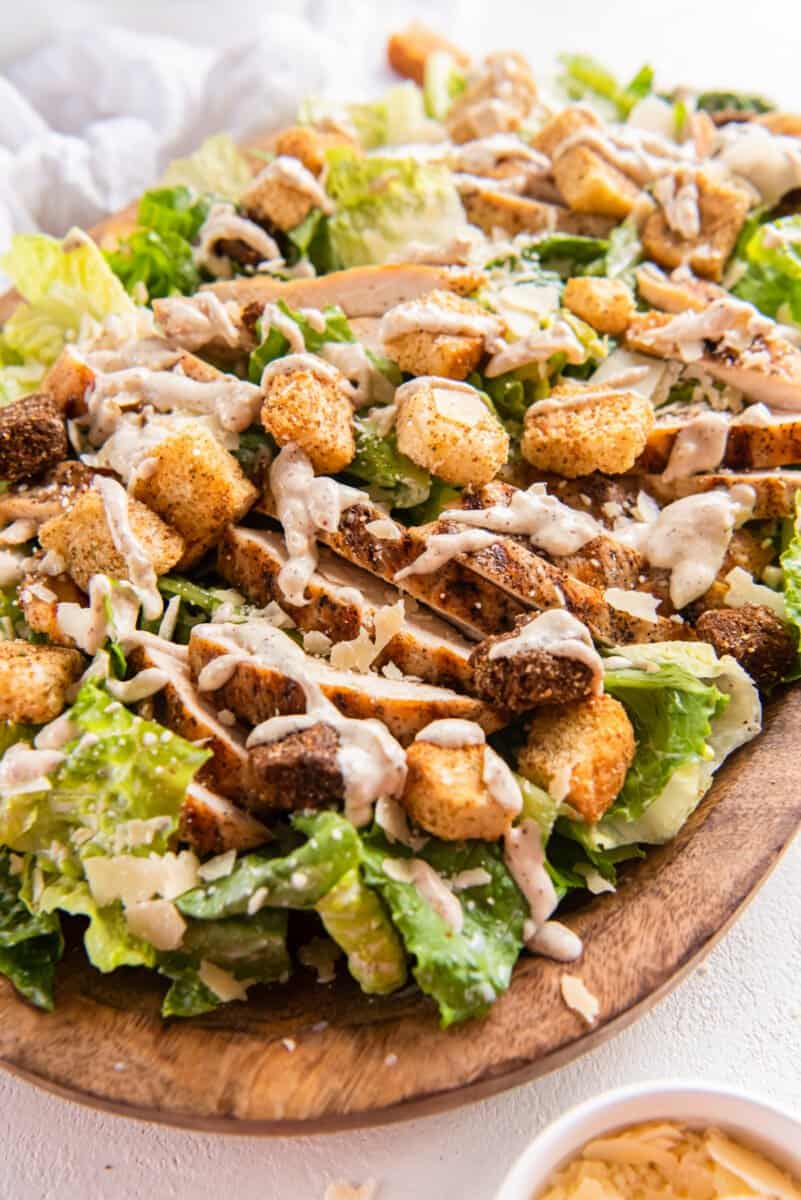 chicken caesar salad in a wooden serving bowl.