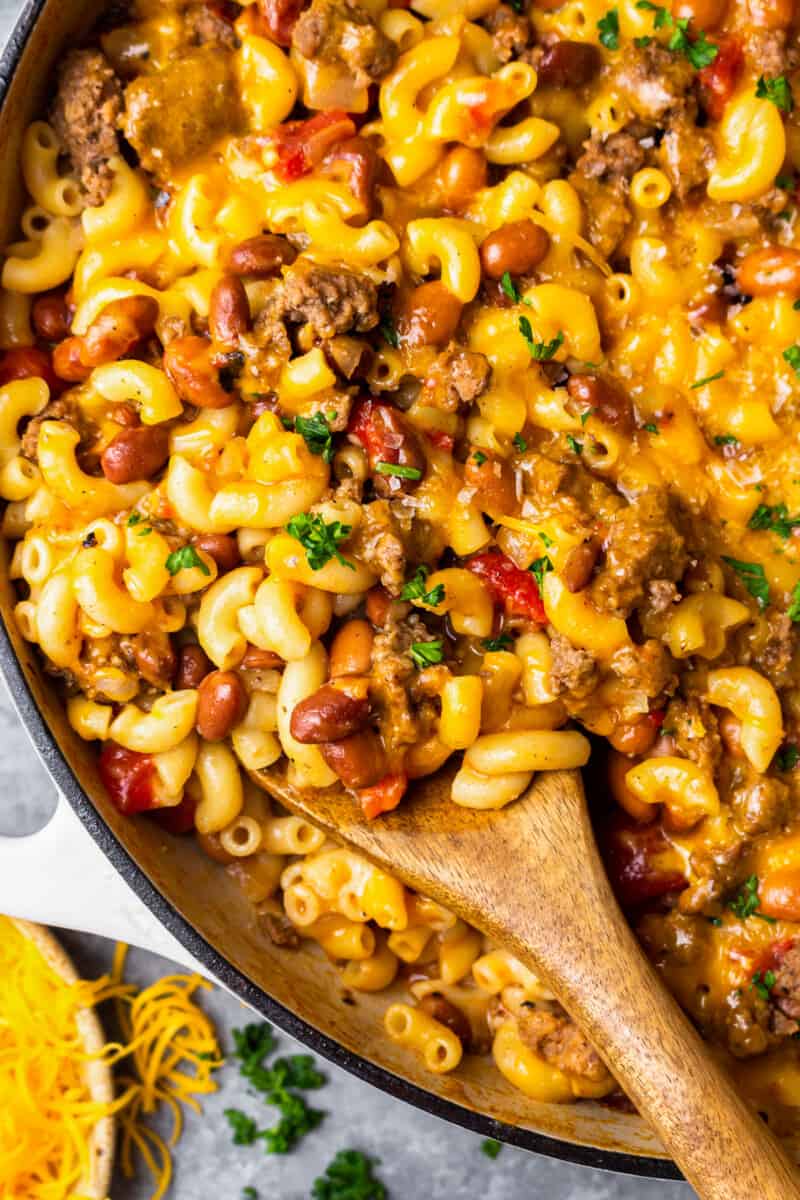 wooden spoon laying in a pot of chili mac