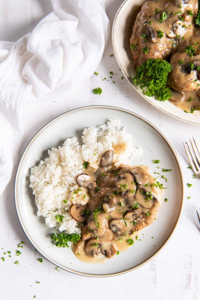 crockpot chicken marsala with white rice on a white plate.