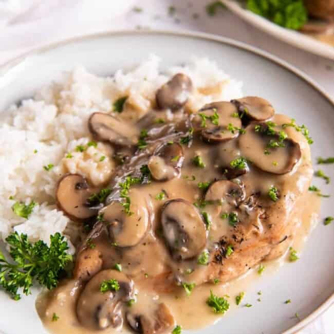 crockpot chicken marsala with white rice on a white plate.