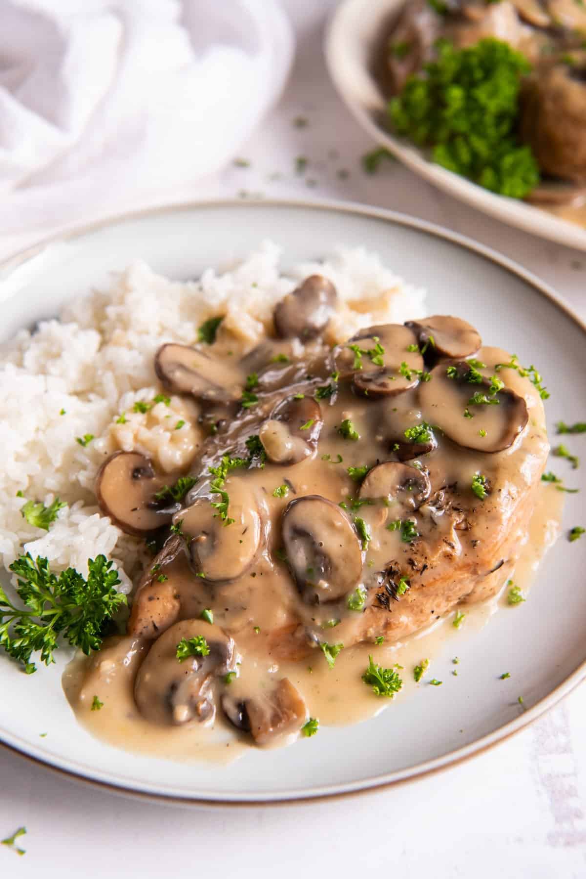 crockpot chicken marsala with white rice on a white plate.