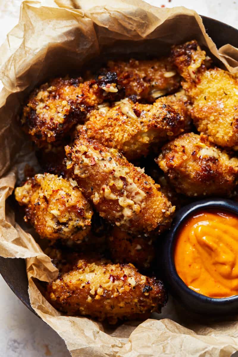 a basket of crockpot wings with sauce