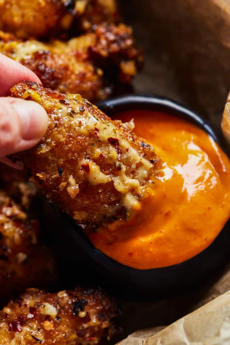 dipping a chicken wing in sauce