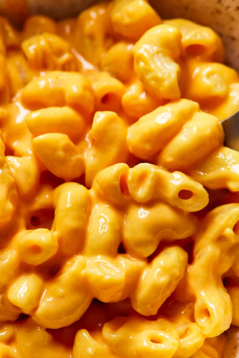 Crock Pot Mac and Cheese is a super simple recipe! This easy slow cooker macaroni and cheese makes the perfect side dish or weeknight dinner. It's virtually fool proof and comes out extra creamy and extra cheesy every time. Mac n cheese is always one of the best cheesy comfort foods around! close up on creamy crockpot mac and cheese