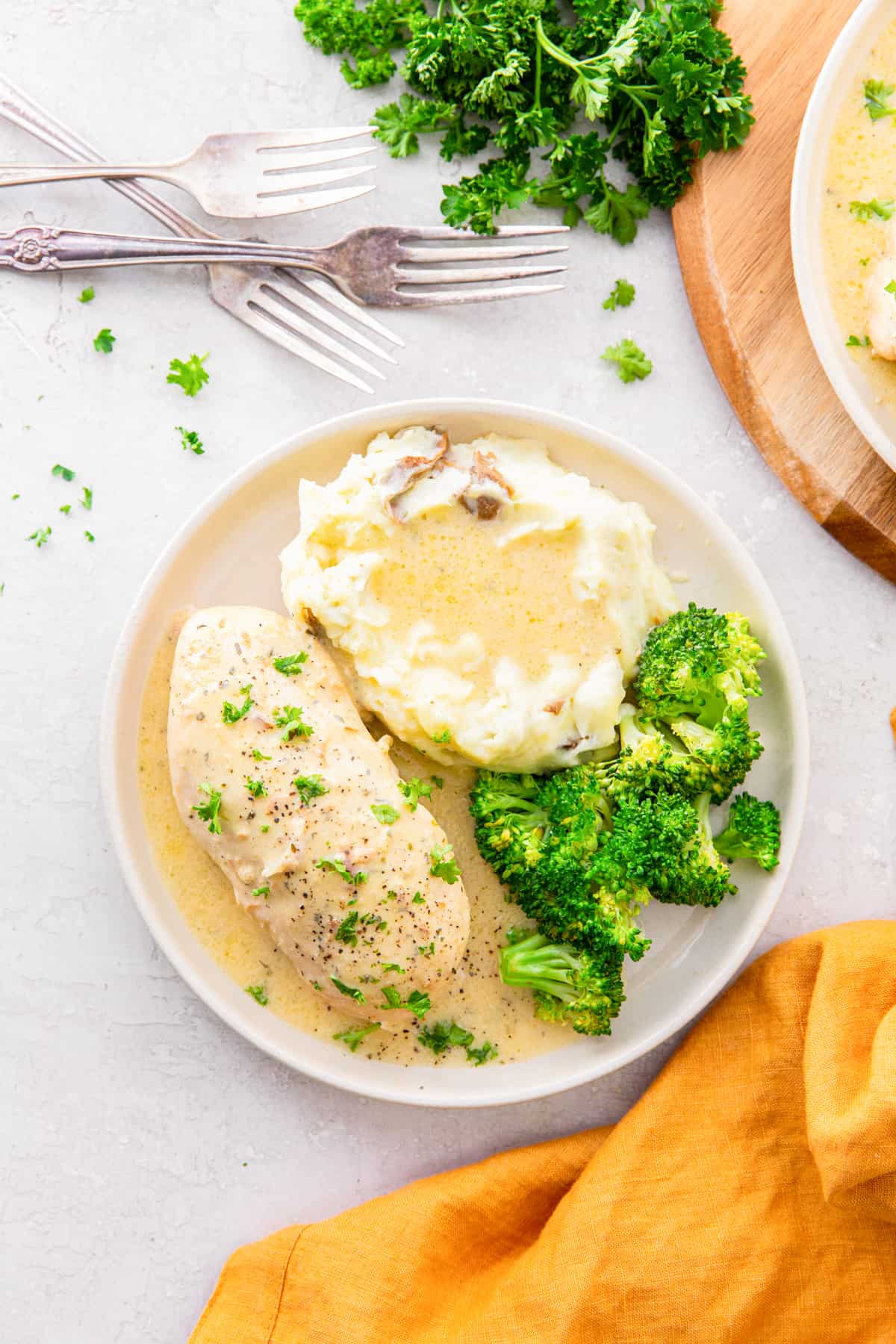 crockpot ranch chicken on a white plate with mashed potatoes.