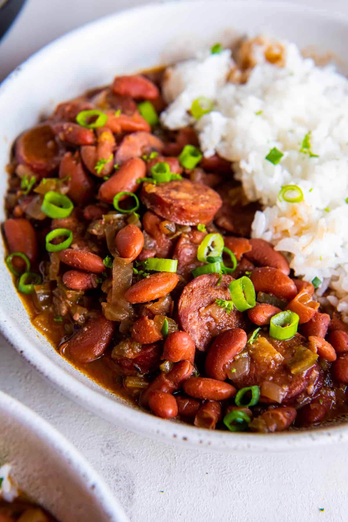 close up of crockpot red beans and rice in a white bowl.