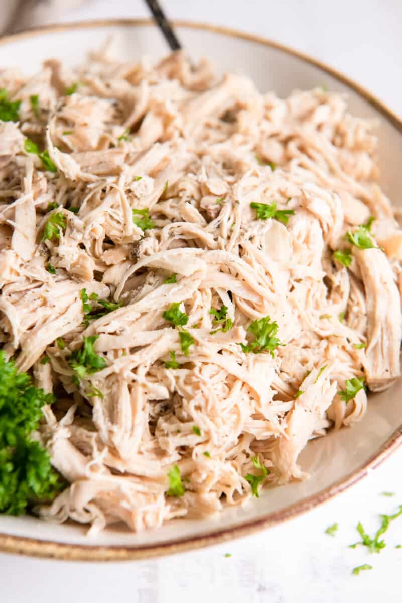 crockpot shredded chicken in a white bowl.