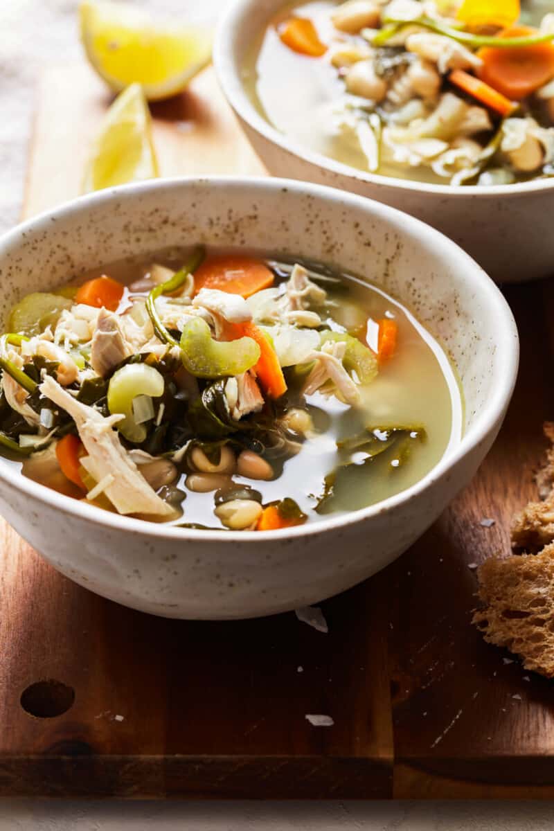 bowl of tuscan soup with chicken, white beans, and spinach