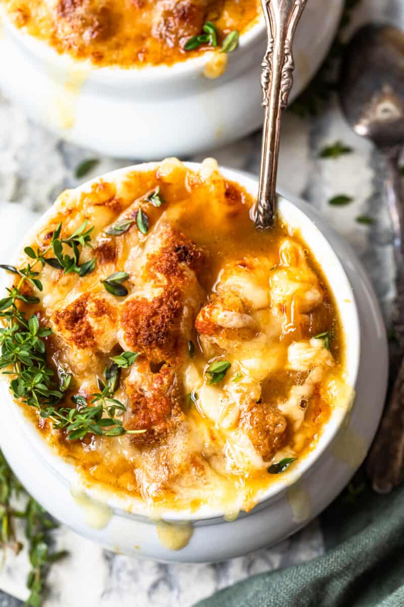 french onion soup in a white bowl with a spoon.