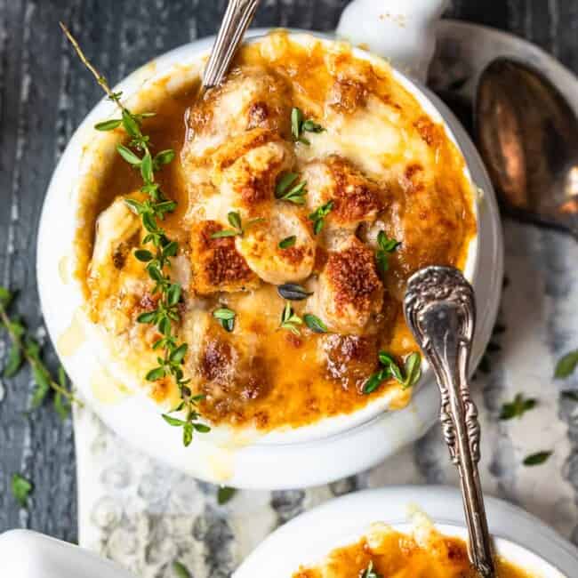 bowls of french onion soup with spoons.