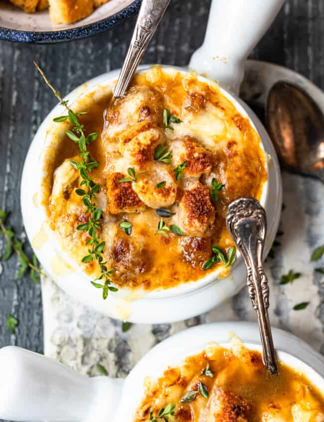 bowls of french onion soup with spoons.