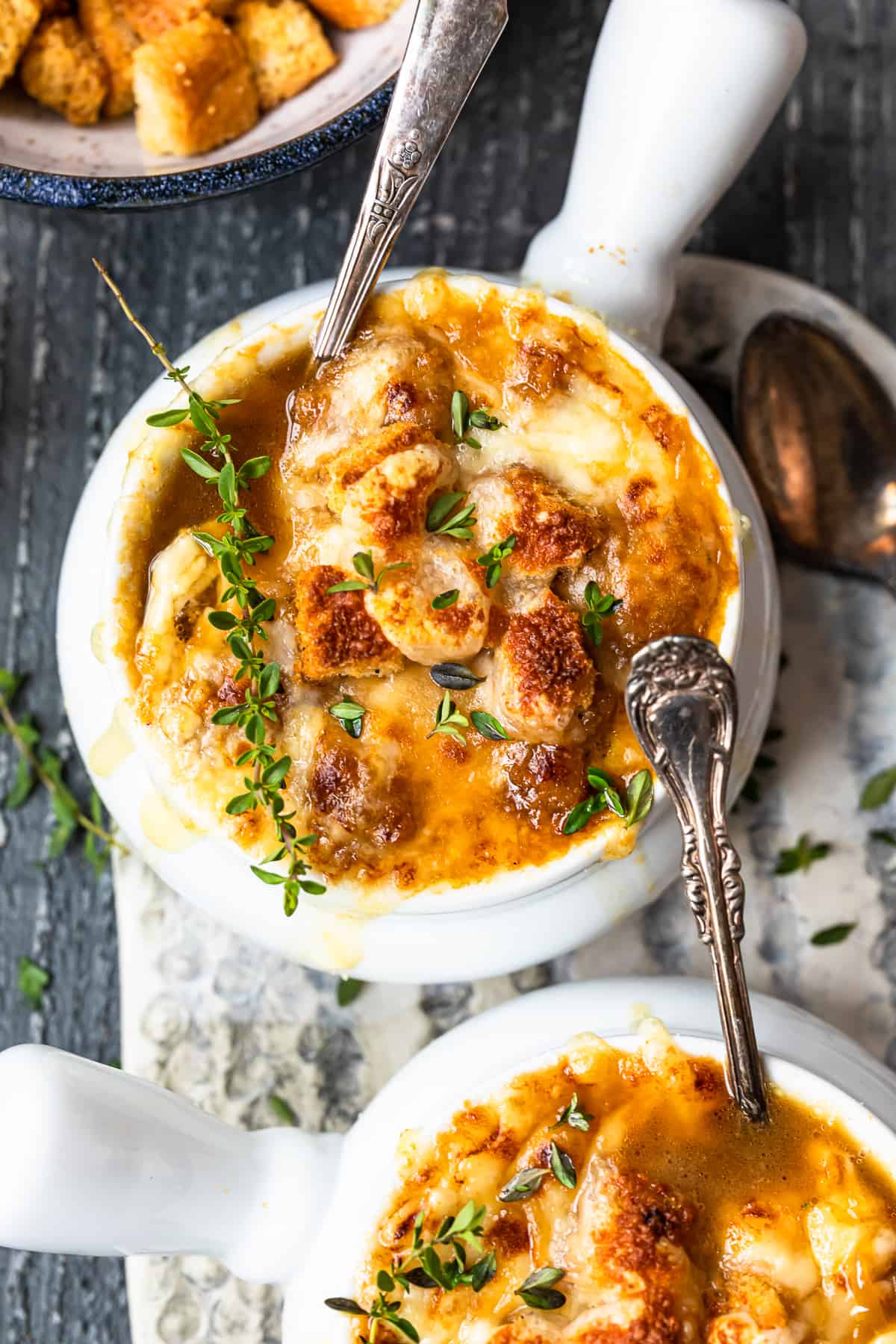 bowls of french onion soup with spoons.