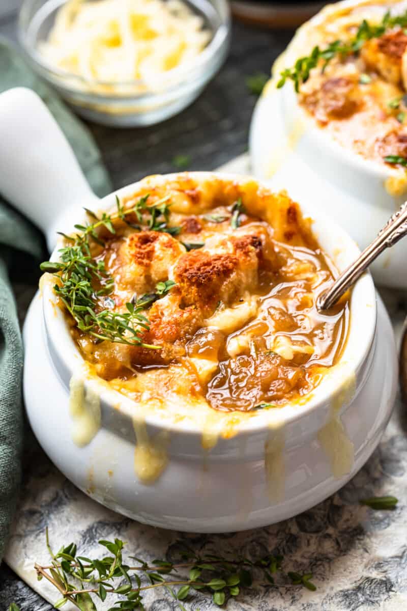 french onion soup in a white bowl with a spoon.