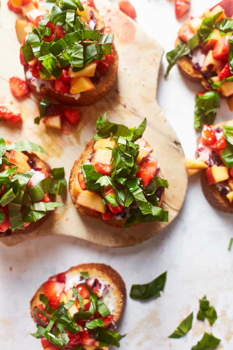 bruschetta appetizer topped with peach, strawberry, and basil