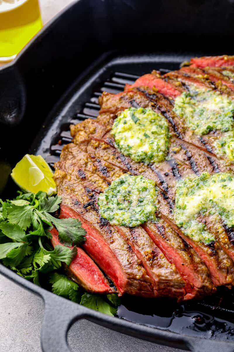 grilled flank steak sliced and topped with pats of cilantro lime butter