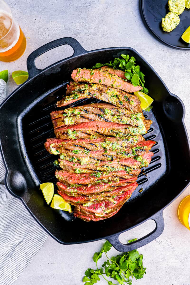 grill pan with flank steak, lemon slices, and cilantro