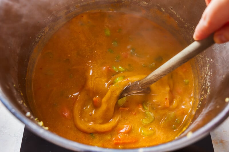 stirring soup in a pot