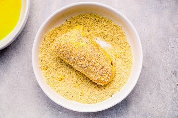 chicken cordon bleu dipped in breadcrumbs in a white bowl.