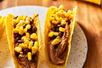 shredded chicken tacos topped with black beans and corn