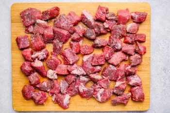 cubed stew meat on a cutting board.